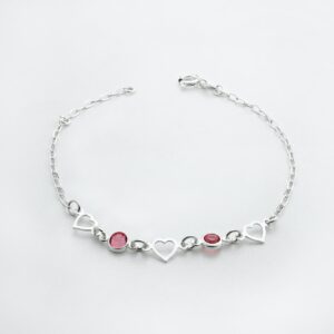 a silver bracelet with hearts and two red stones