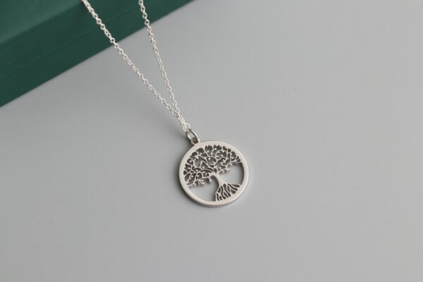 a silver tree of life pendant on a chain